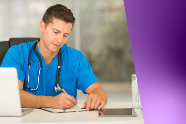 Healthcare provider in blue scrubs reviewing patient billing documents with a laptop, representing efficient medical practice management and faster claims processing.