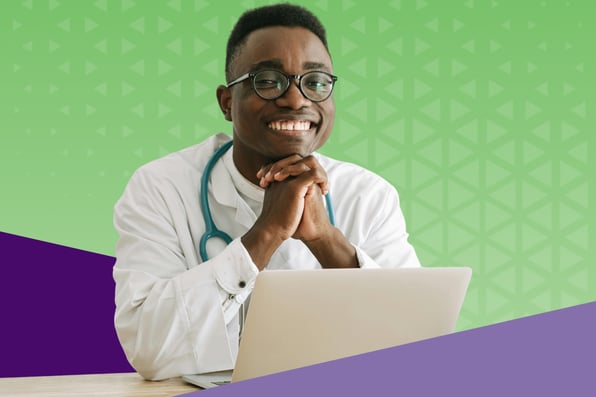  A smiling male doctor wearing glasses and a stethoscope sits at a desk with a laptop, hands clasped under his chin, against a green and purple background. The image conveys confidence, professionalism, and modern healthcare technology.